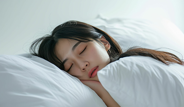 ぐっすりベッドで眠る女性の画像